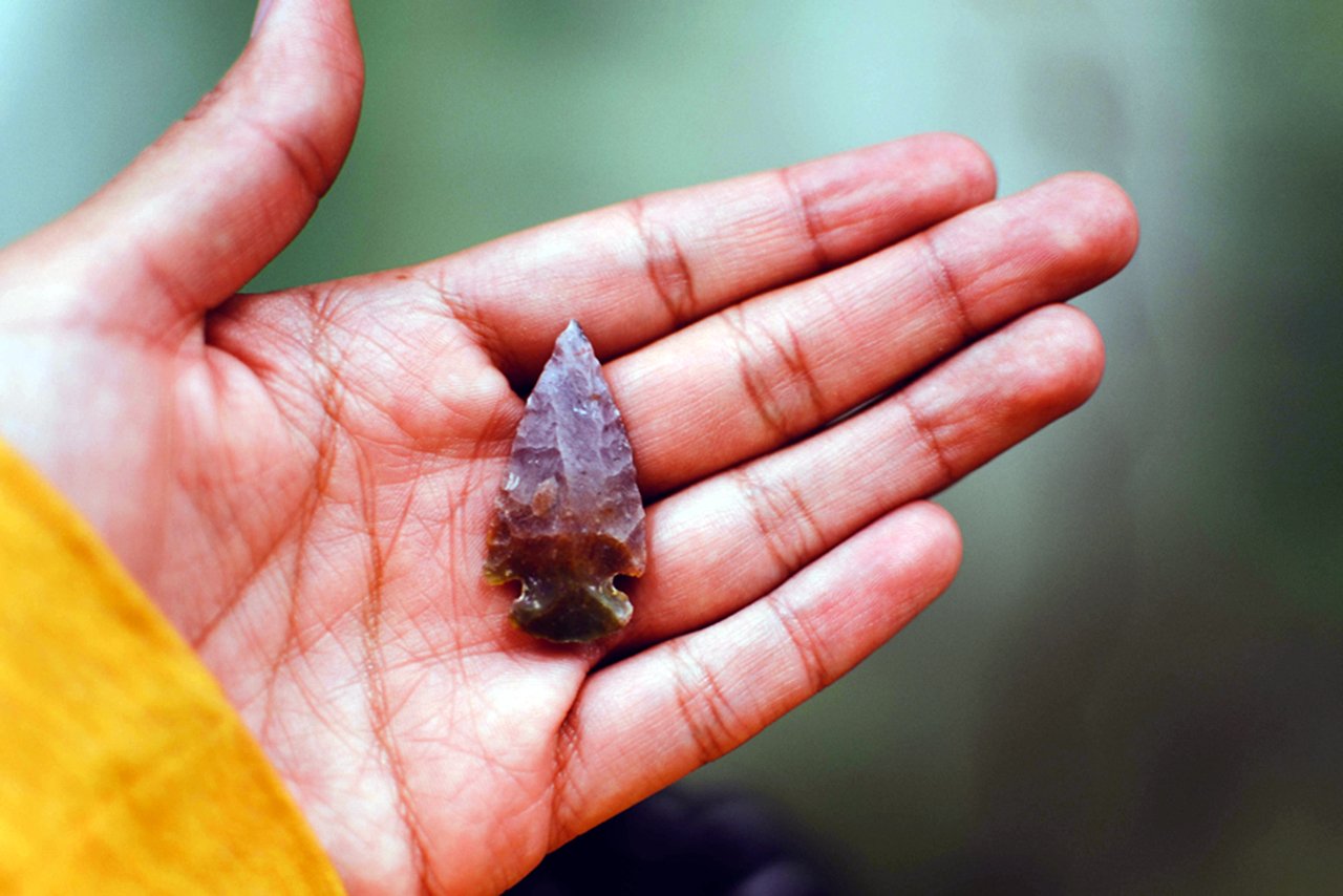 person holding an arrowhead